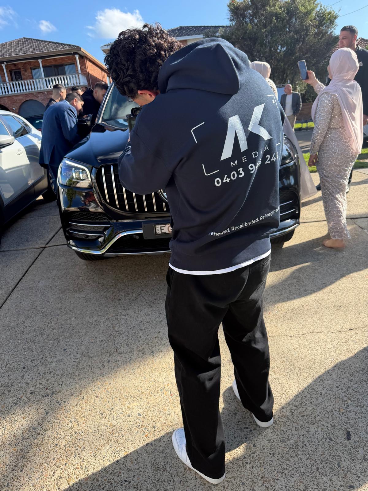 Ibby filming on location, wearing his AK Media hoodie